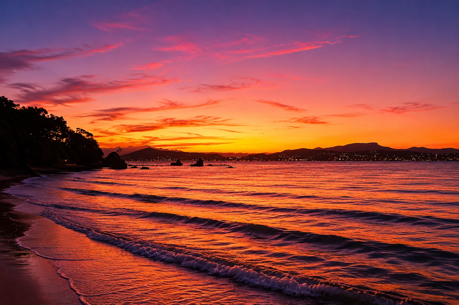Pôr do sol intenso sobre o mar — laranja, rosa e roxo refletidos nas ondas